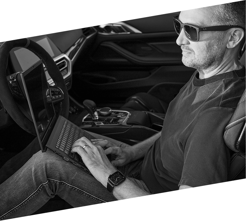 The Tax Driver, Steuerberater Richard Schweiger, sitzt mit seinem Laptop im Auto